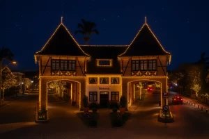 Portal turístico de Pomerode à noite, iluminado com luzes de Natal douradas e decoração festiva, com céu estrelado ao fundo.